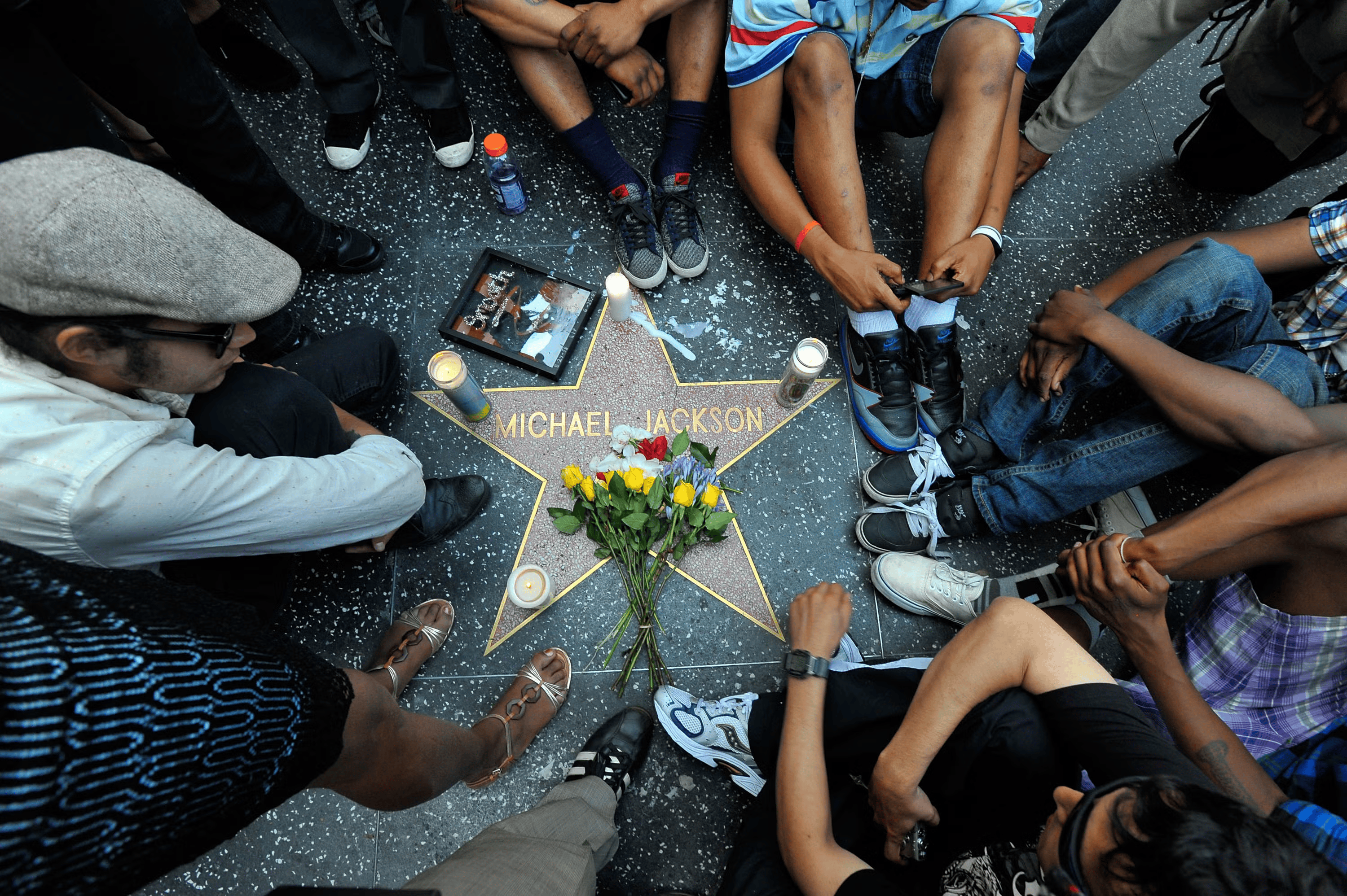 Fans of Michael Jackson sit vigil at his star on the Hollywood Walk of Fame following the singer’s death on June 25, 2009, in Los Angeles, California